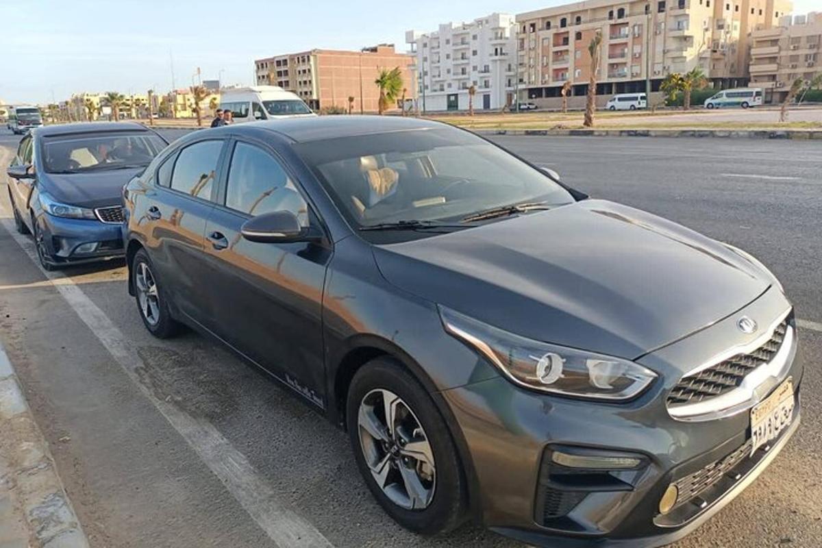 Un coche plateado y negro estacionado en un estacionamiento.