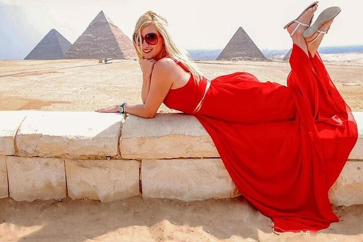 žena ležící na zdi před pyramidami