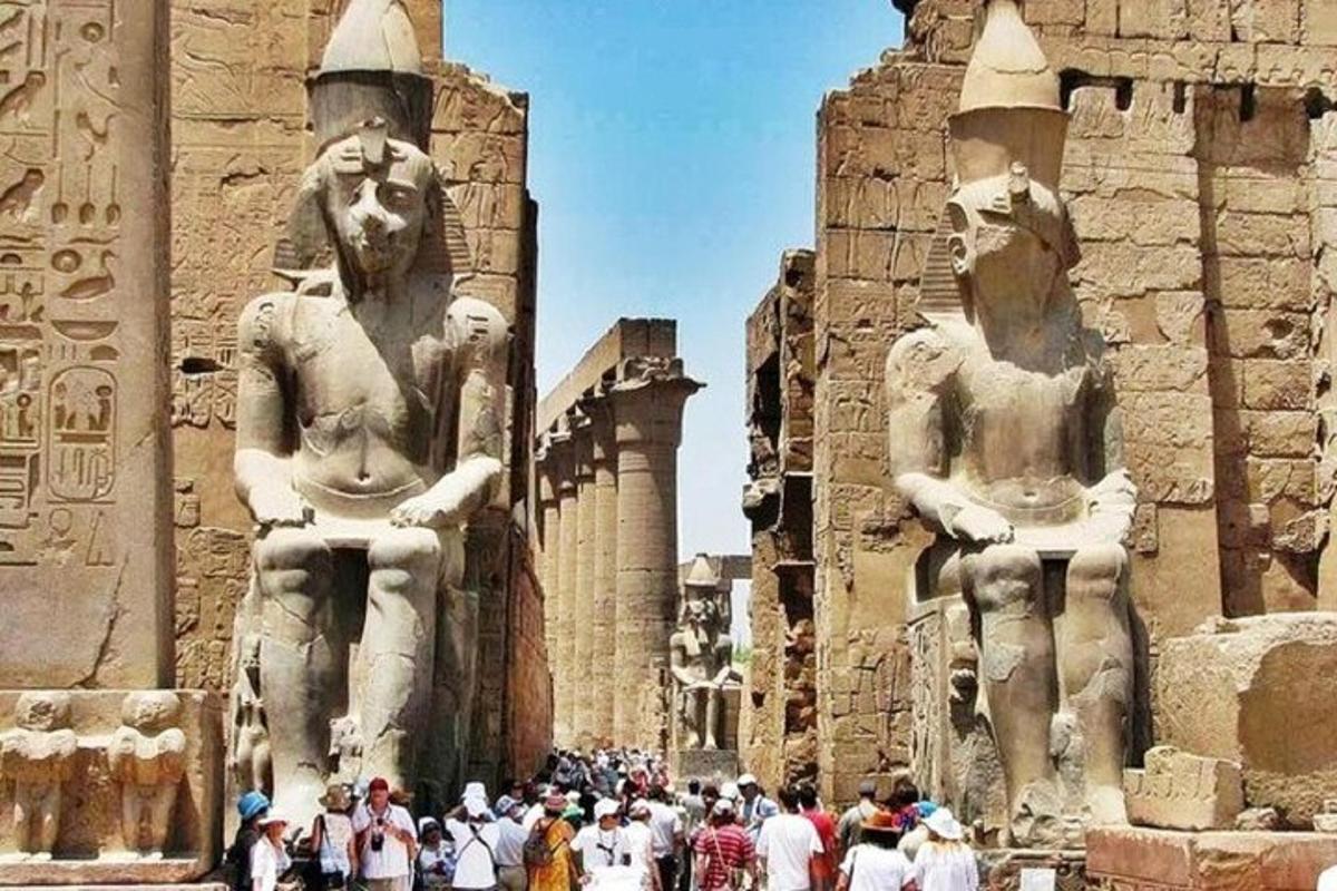un gruppo di persone in piedi davanti a due statue