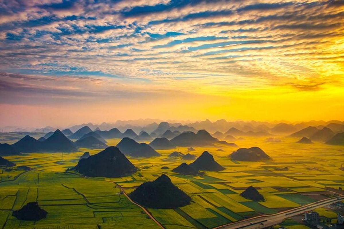 a painting of a sunset over a mountain range