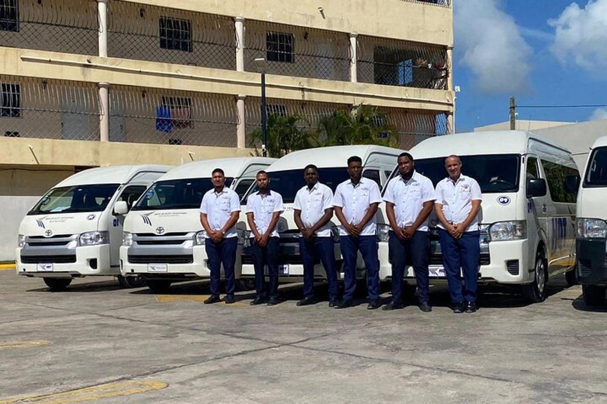a group of men standing in front of white vans
