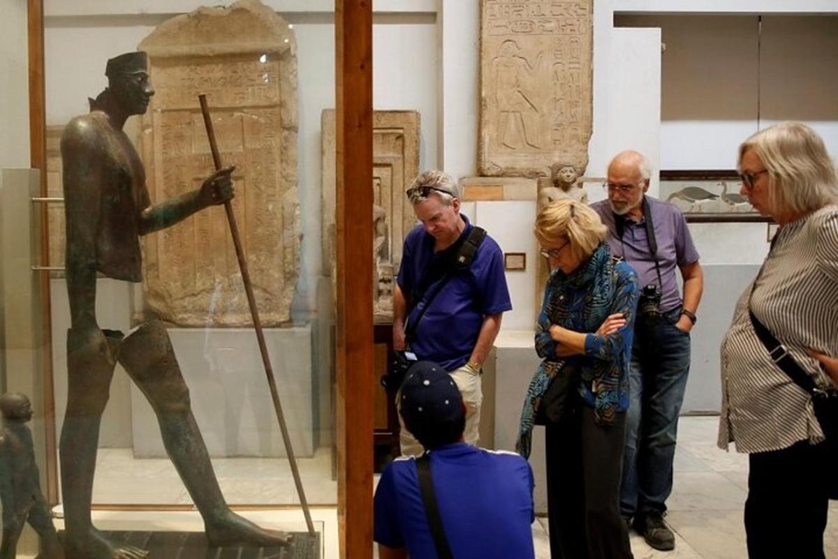 um grupo de pessoas olhando para uma estátua em um museu