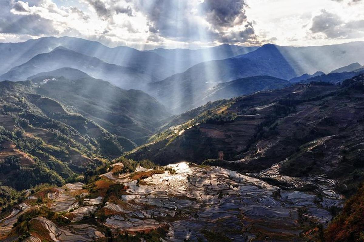 a view of a mountain valley with rays of sunlight