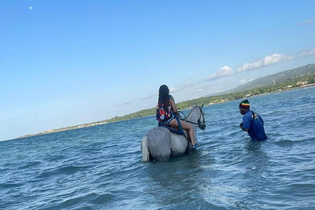 bir kadın bir adamla birlikte suda at sırtında