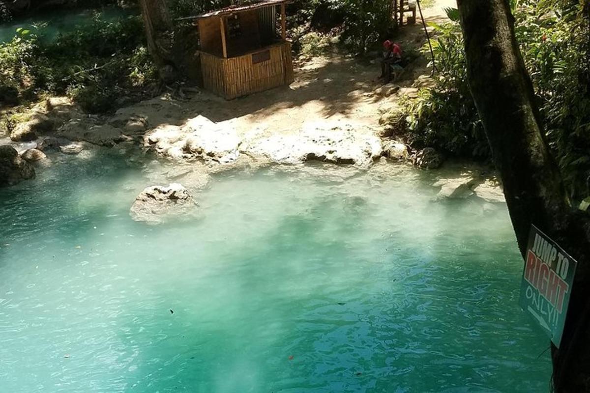 μια μπλε λίμνη με νερό και ένα άτομο να στέκεται μέσα σε αυτήν