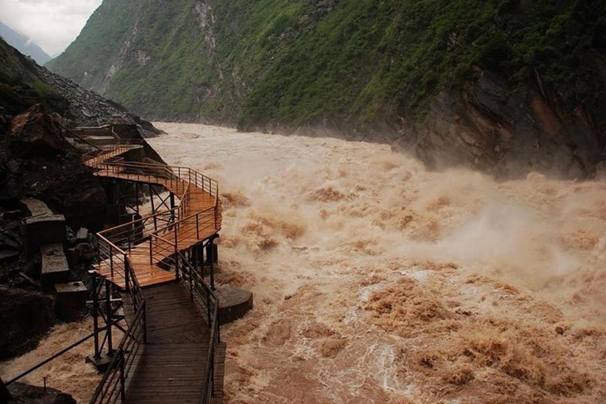 a wooden walkway in a river with muddy water