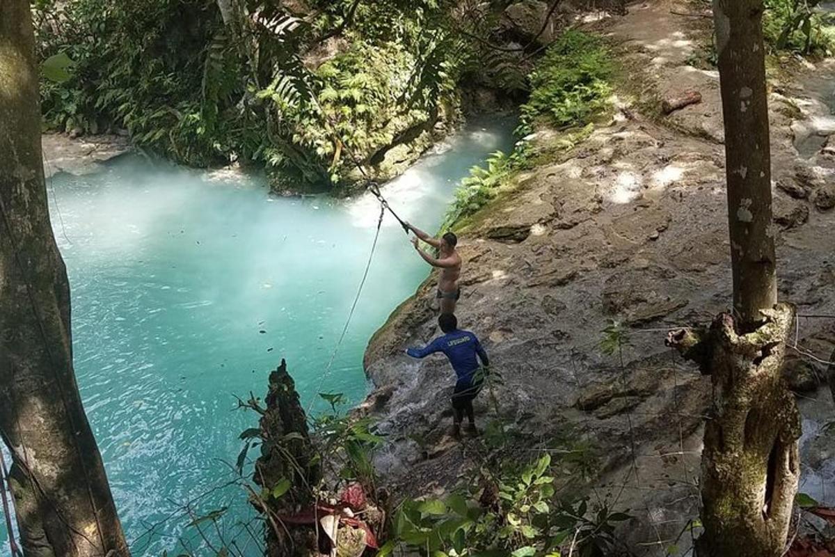 isang lalaking nakabitin sa isang lubid sa ibabaw ng ilog