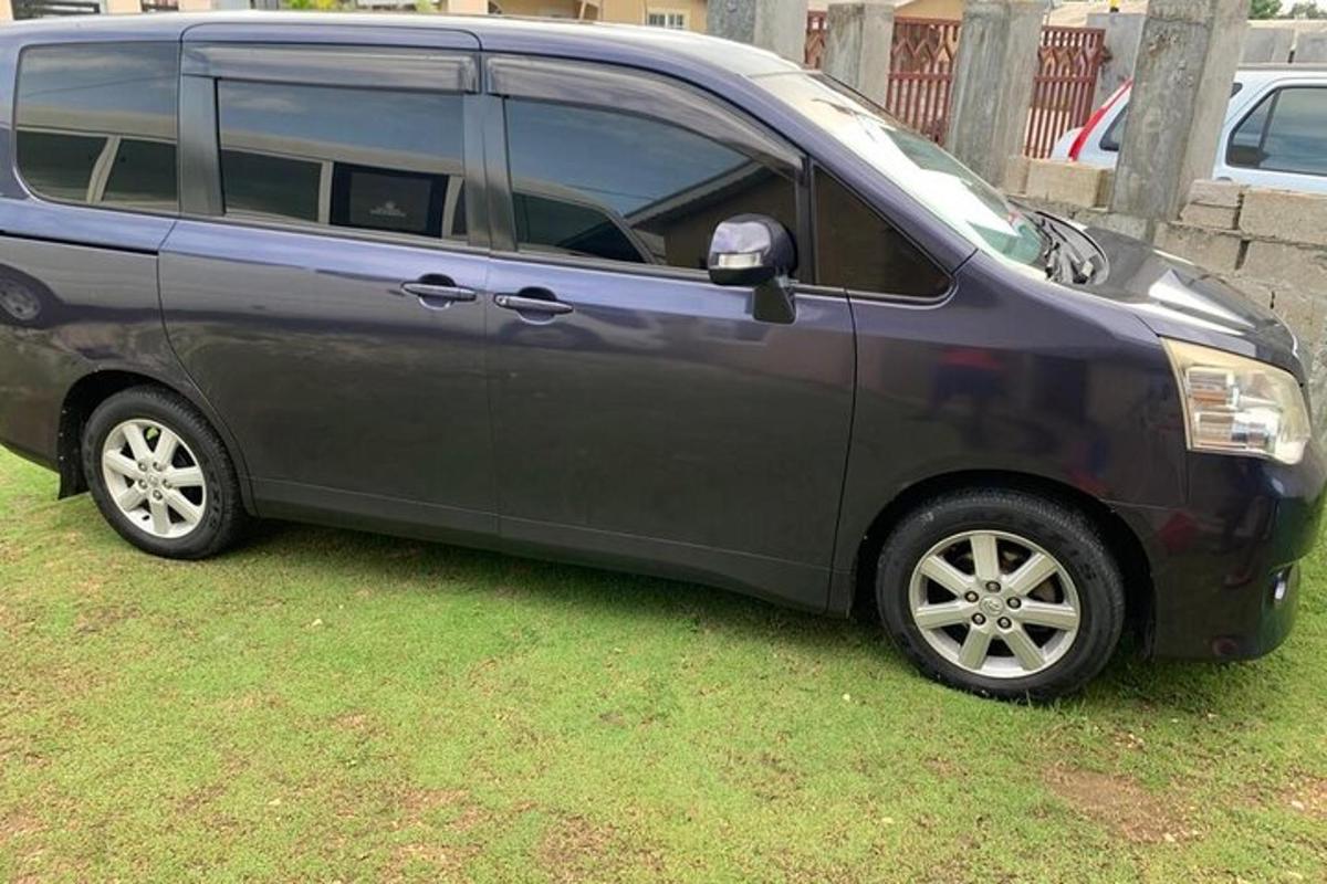 šedý minivan zaparkovaný na travnatém poli