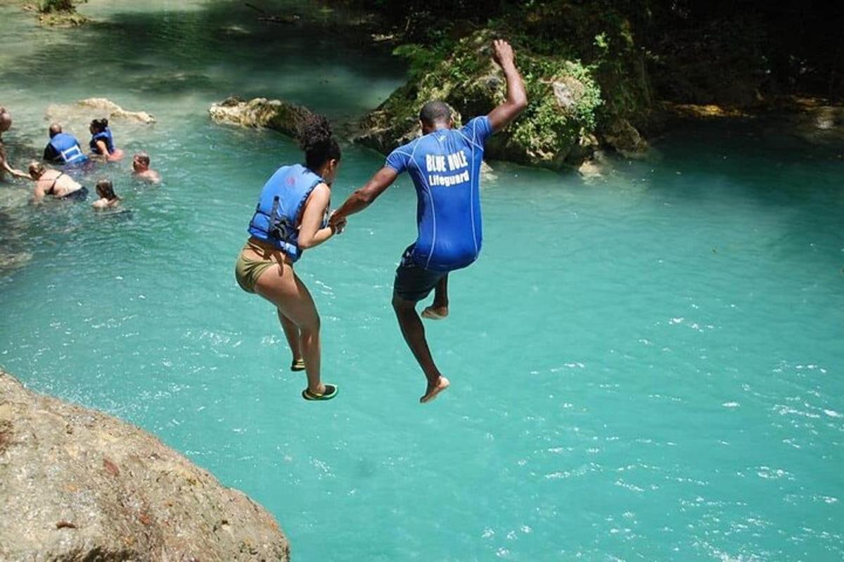 Un par de personas saltando a un cuerpo de agua