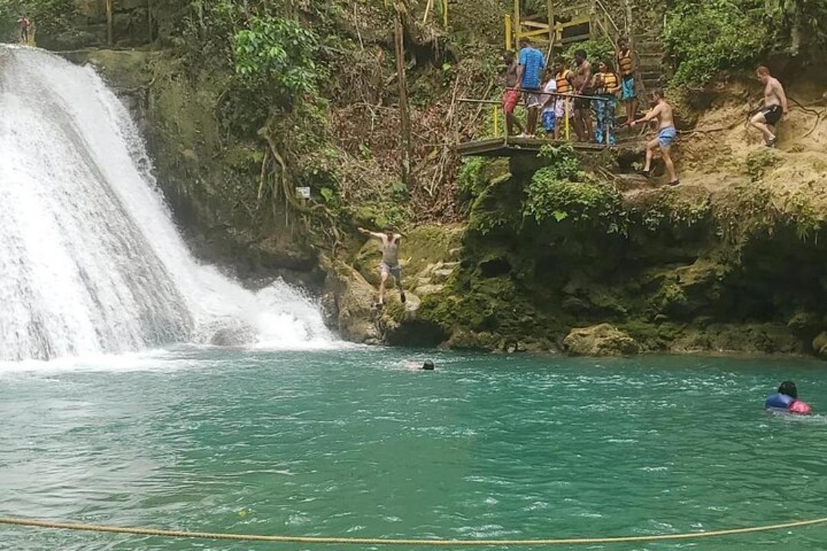 un gruppo di persone in acqua vicino a una cascata