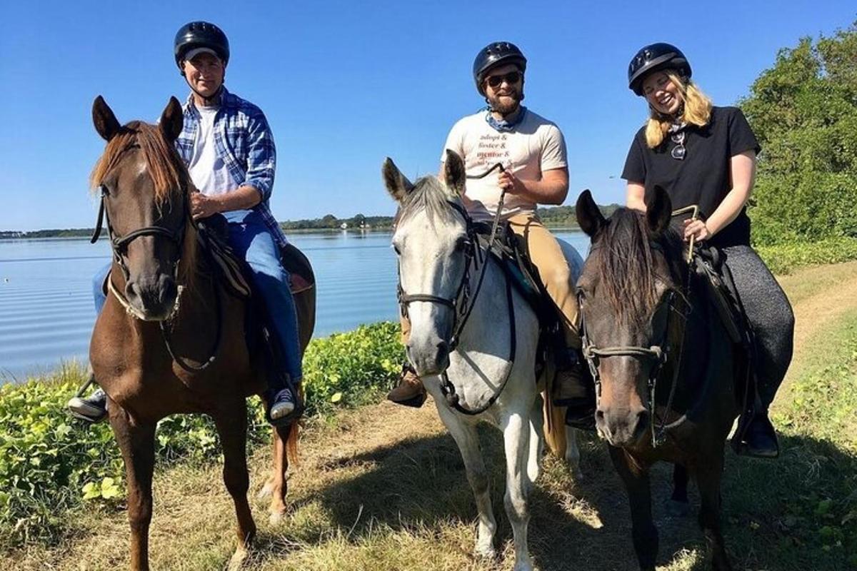 un gruppo di persone a cavallo in riva all'acqua