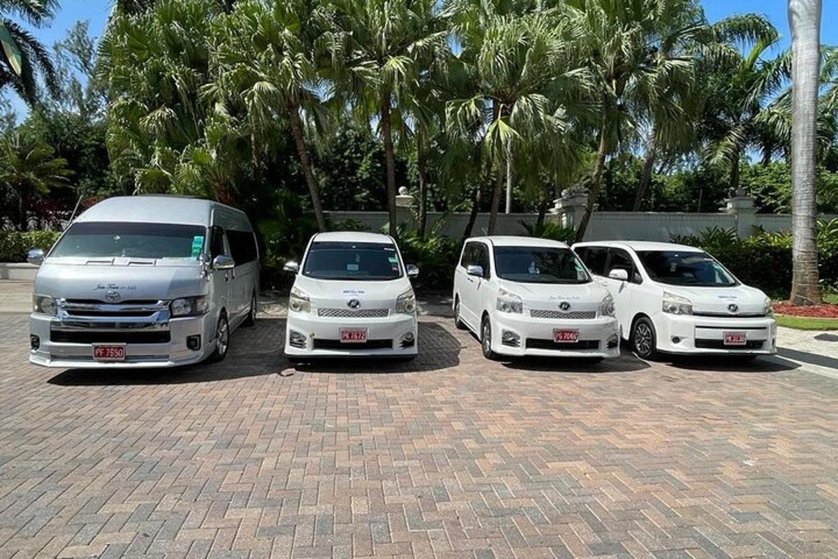 um grupo de três carros brancos estacionados em um estacionamento