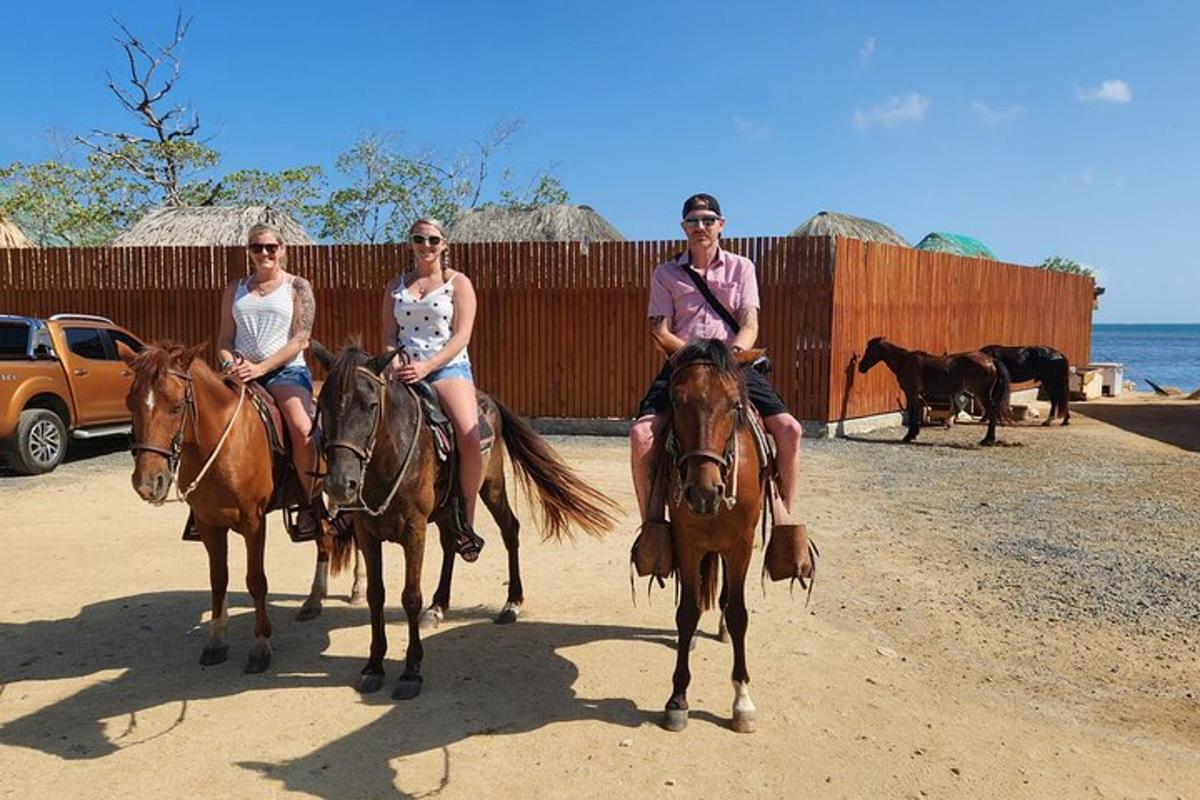three people are riding horses on the beach