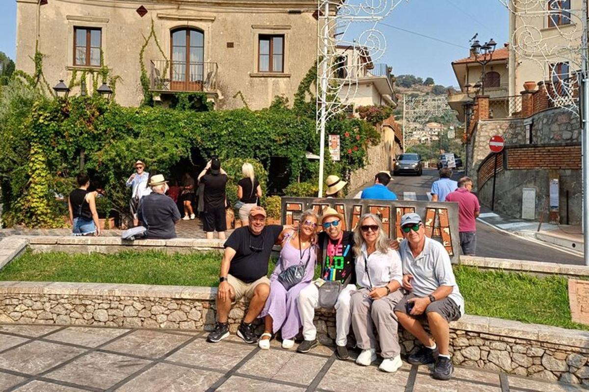 skupina lidí pózujících pro fotografii před budovou