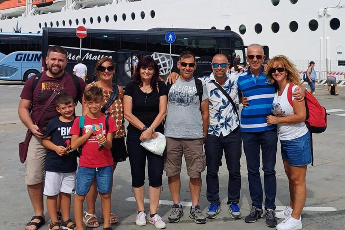 um grupo de pessoas em pé na frente de um ônibus