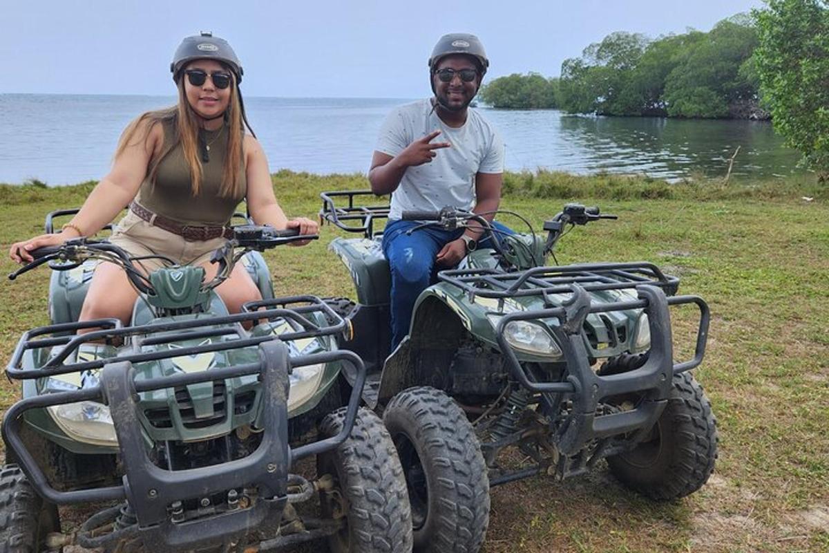 a man and a woman sitting on atvs by the water