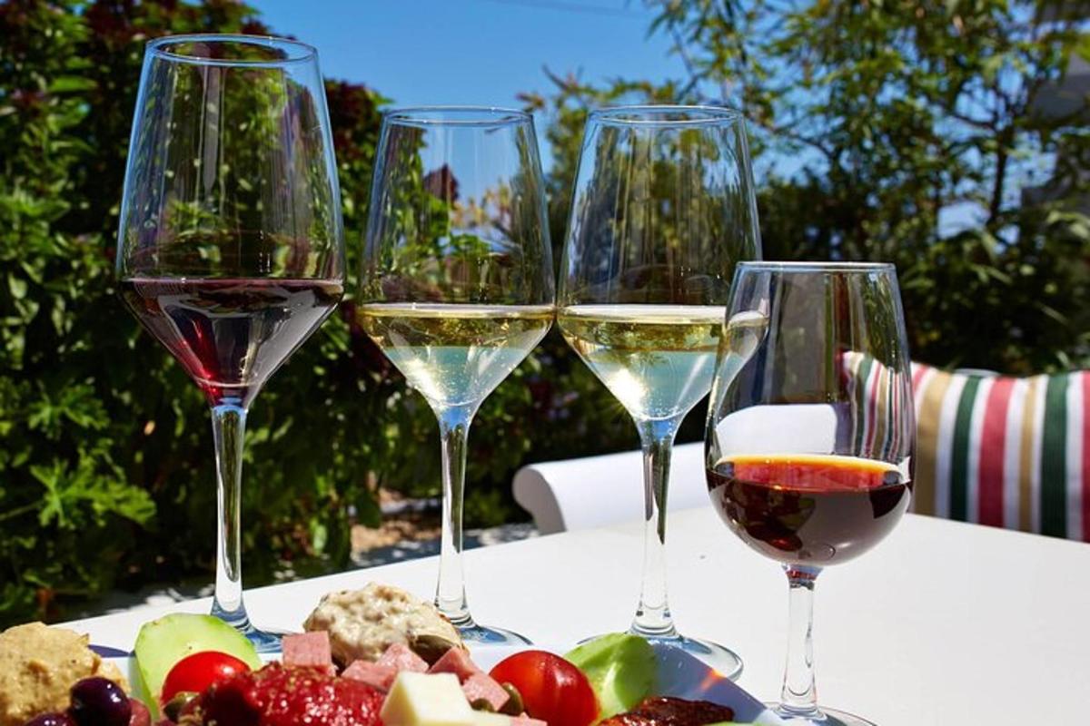 fire glass vin som står på et bord med frukt