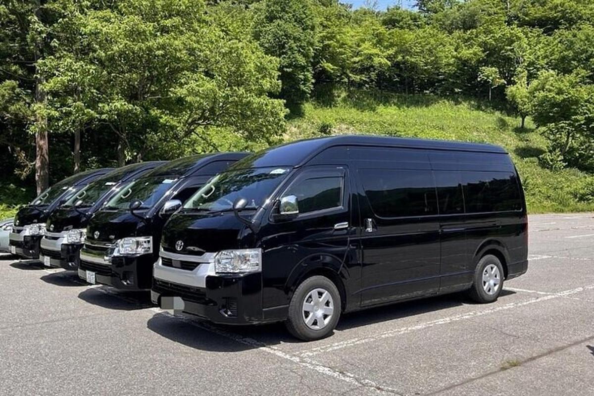 a row of black vans parked in a parking lot