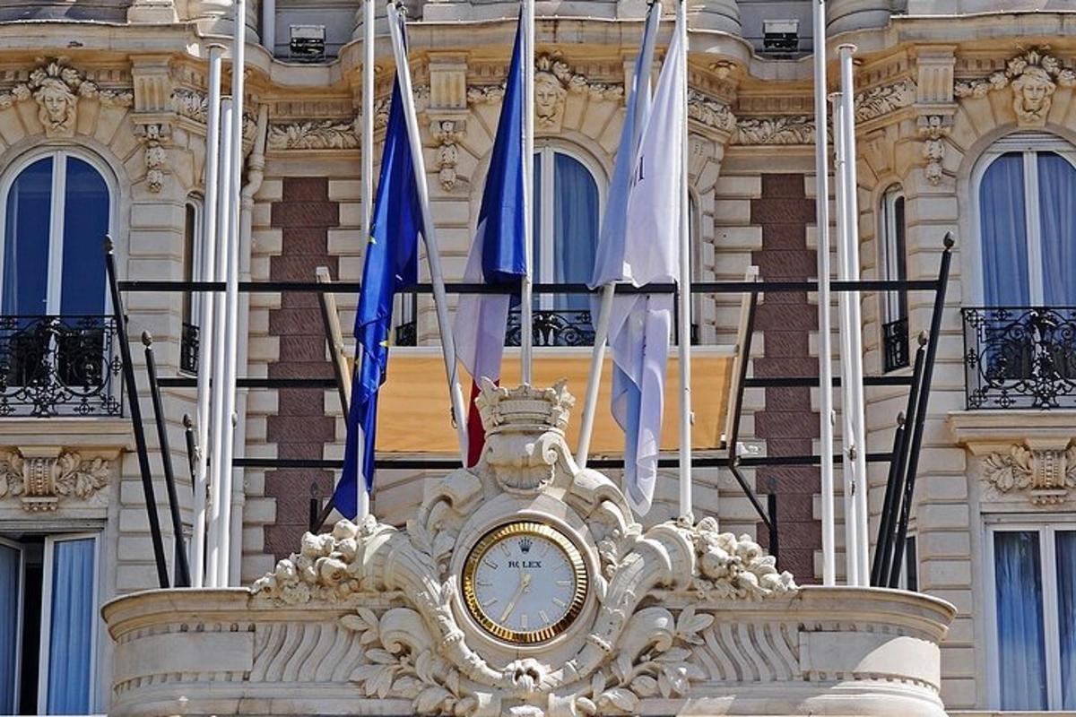 hodiny na priečelí budovy s vlajkami