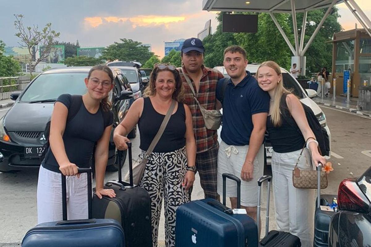 a group of people posing for a picture with their luggage