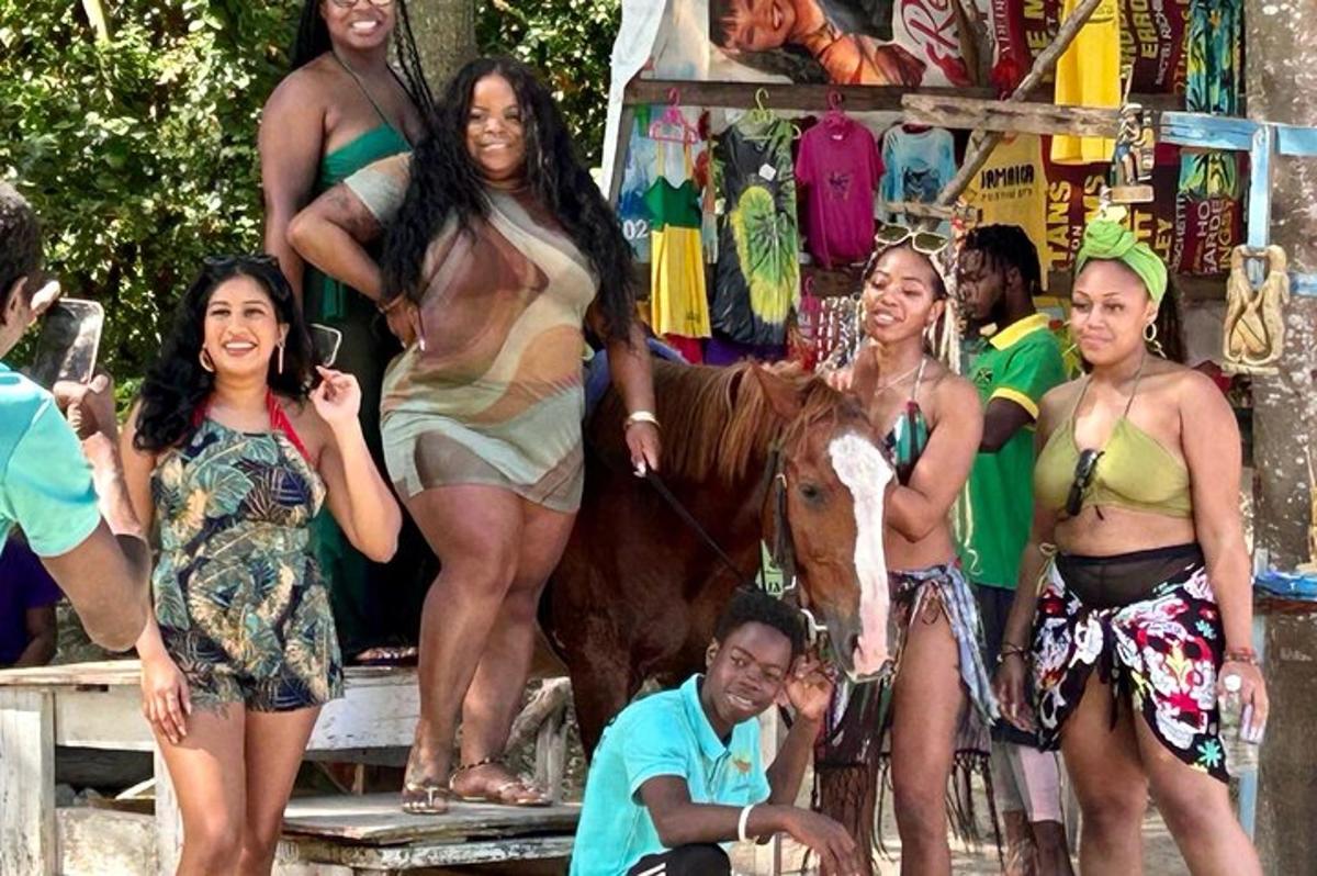 um grupo de mulheres em trajes de banho em pé ao lado de uma vaca
