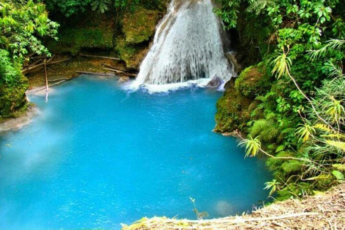 uma cachoeira no meio de uma piscina de água azul