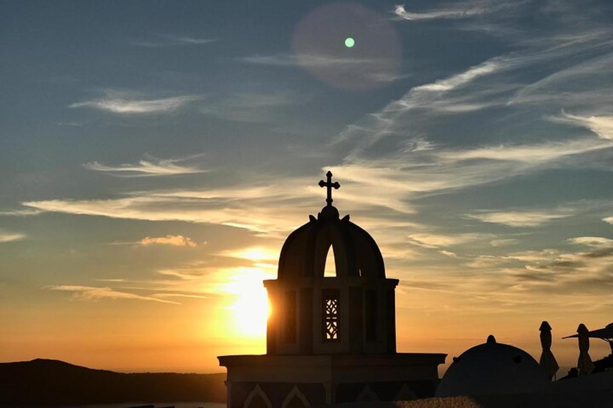 una torre del rellotge amb la posta de sol al fons