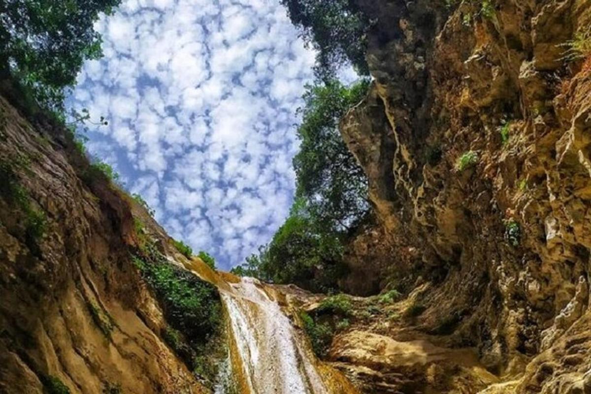 a painting of a waterfall in a rocky canyon