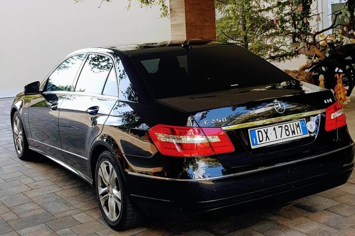 černé auto je zaparkované na příjezdové cestě