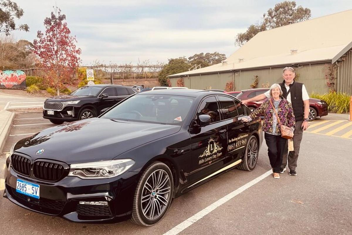 um homem e uma mulher parados ao lado de um carro preto