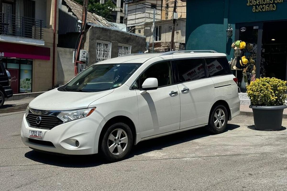 un minivan bianco parcheggiato sul ciglio di una strada