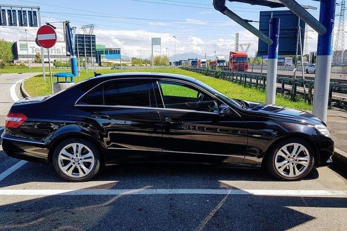 um carro preto está estacionado em um sinal de parada