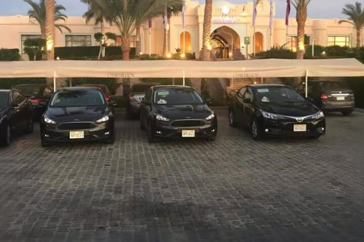 three cars parked in a parking lot in front of a building