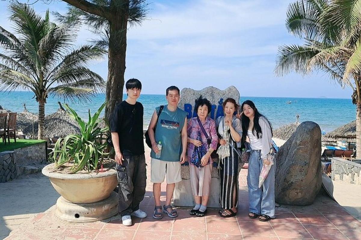um grupo de pessoas posando para uma foto na praia