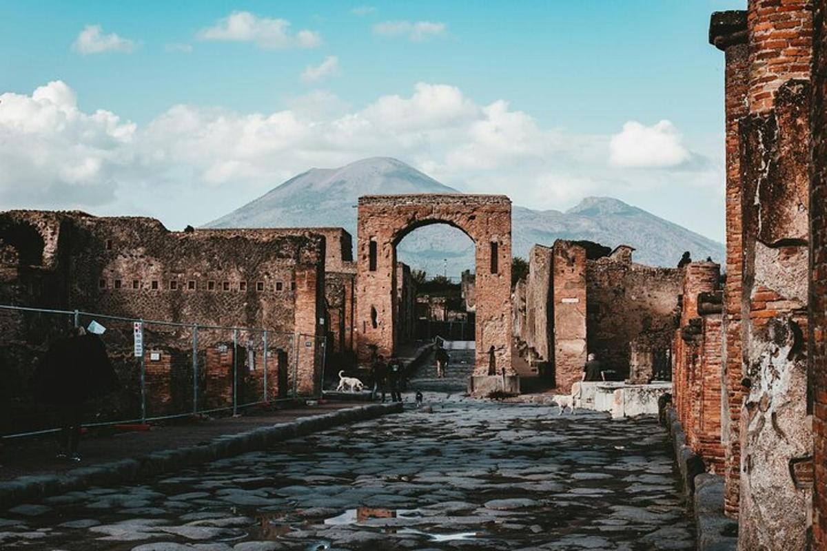 an old building with an arch and a mountain in the background