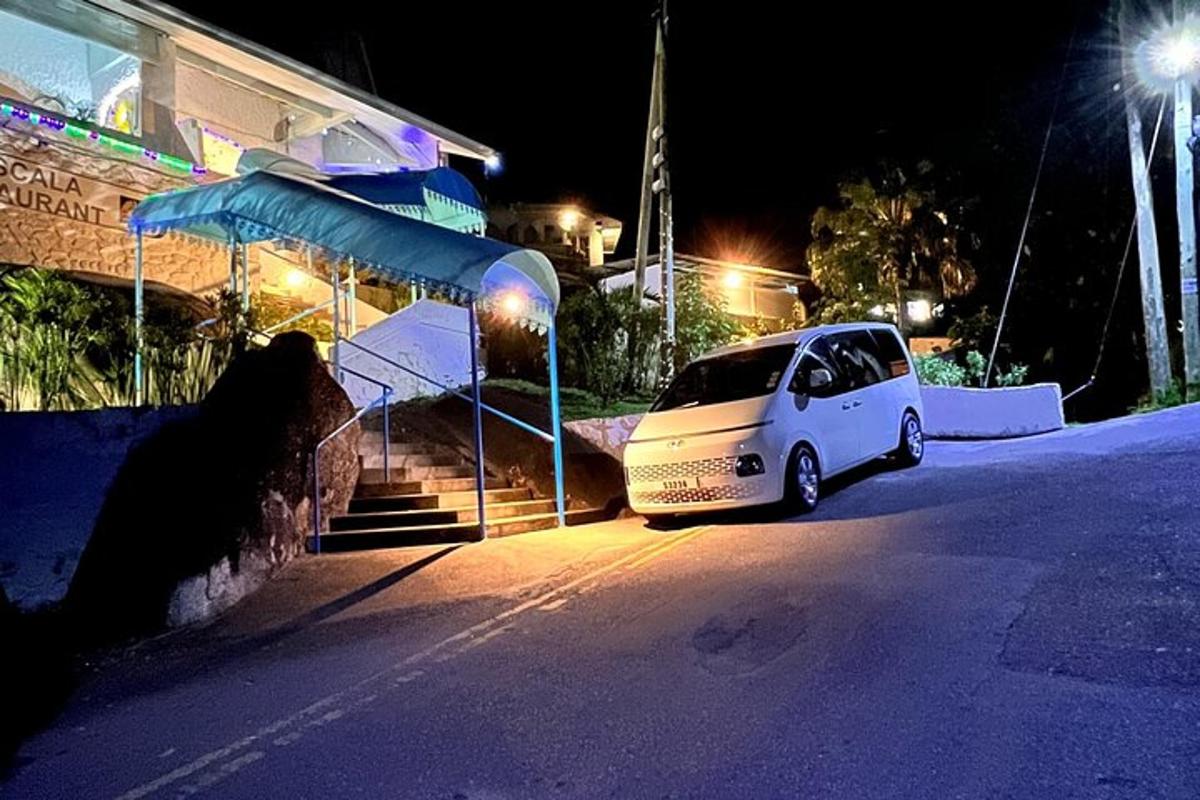 a white car parked next to a building at night