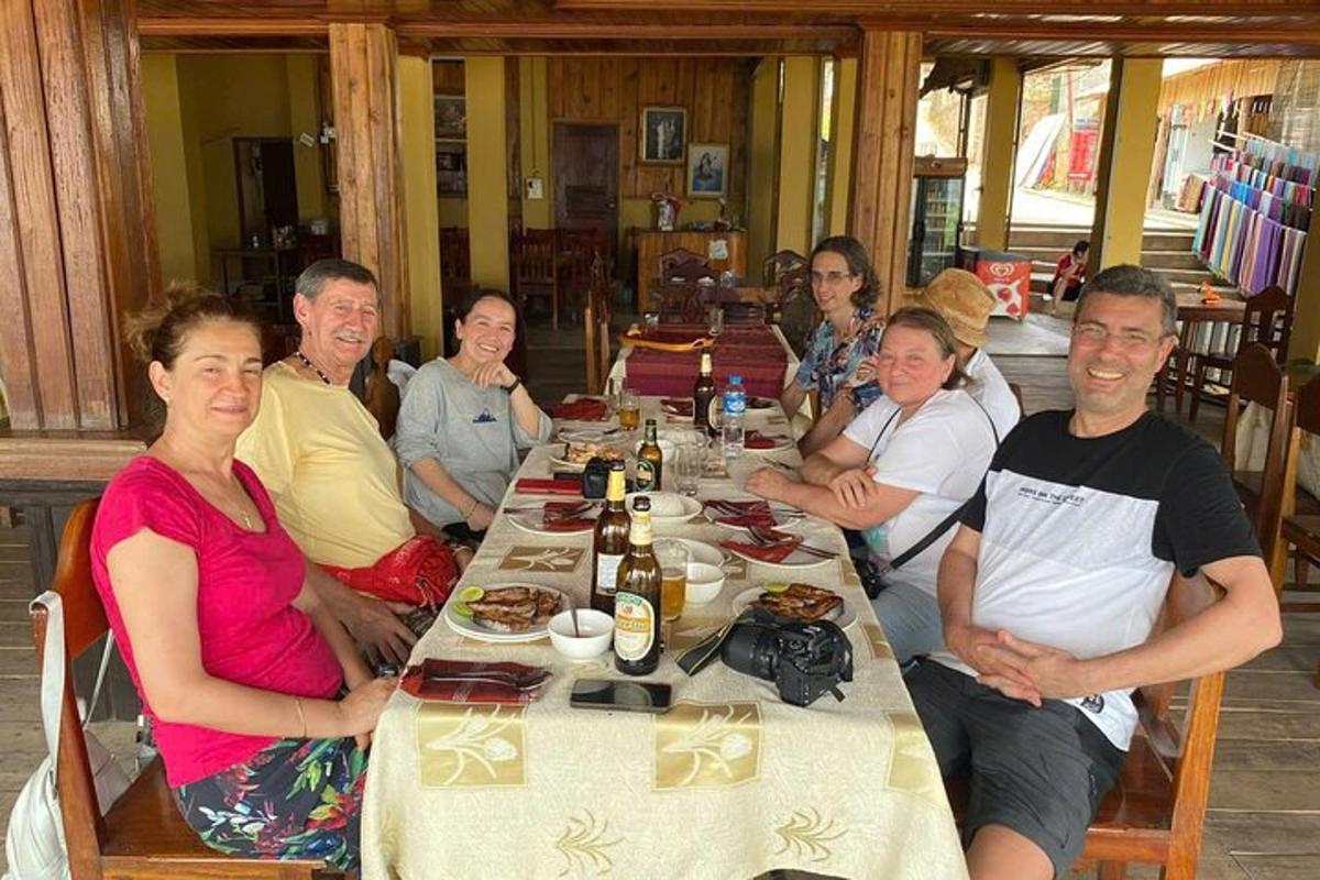 cilvēku grupa, kas sēž ap galdu