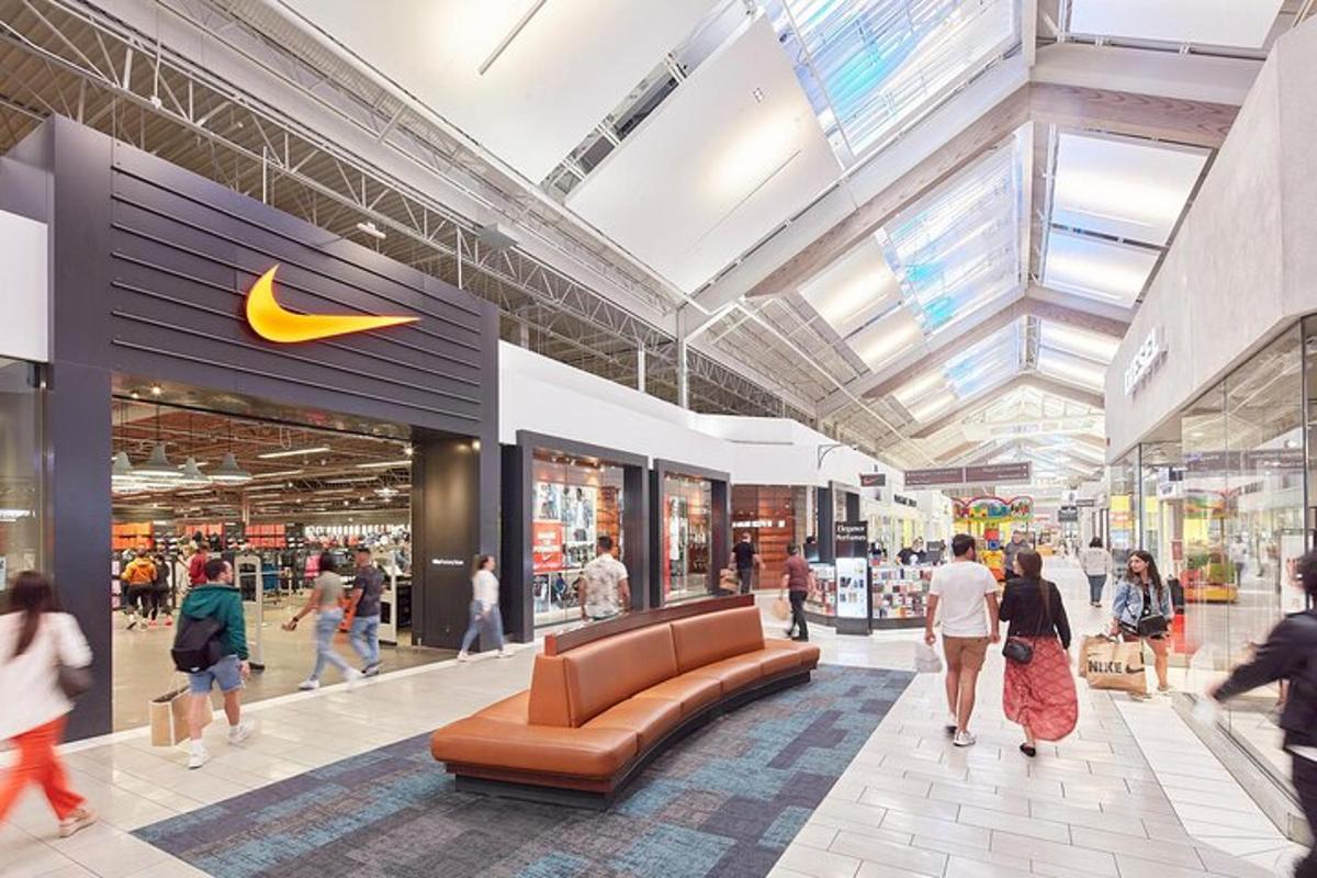 a nike store with people walking in a mall