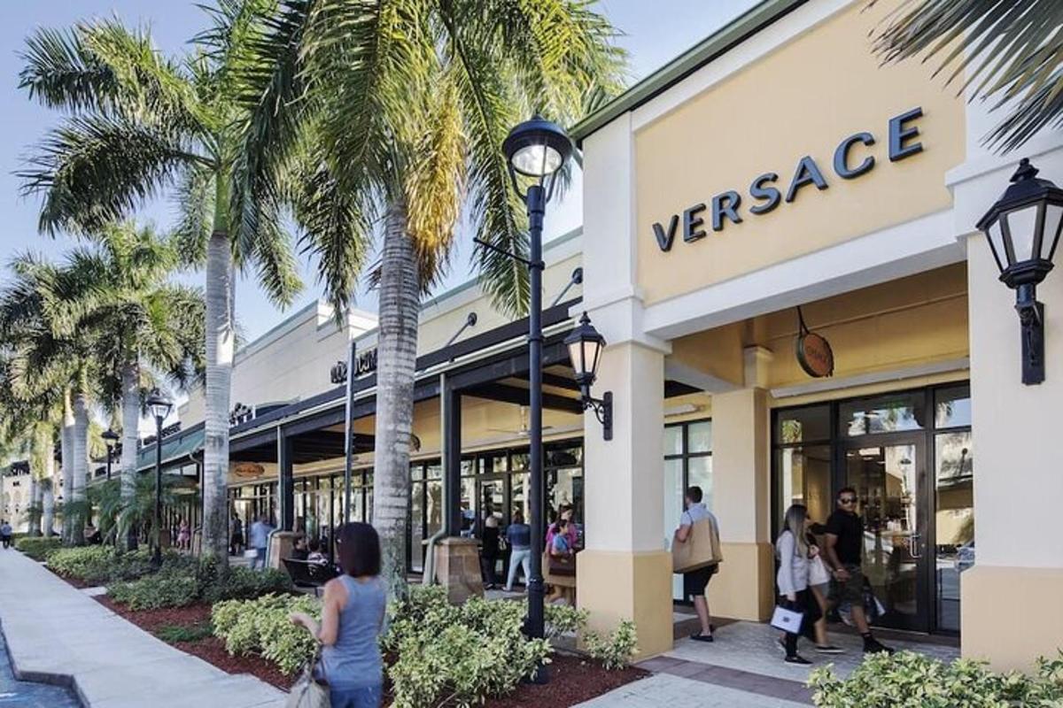 a store front of a versace store with palm trees