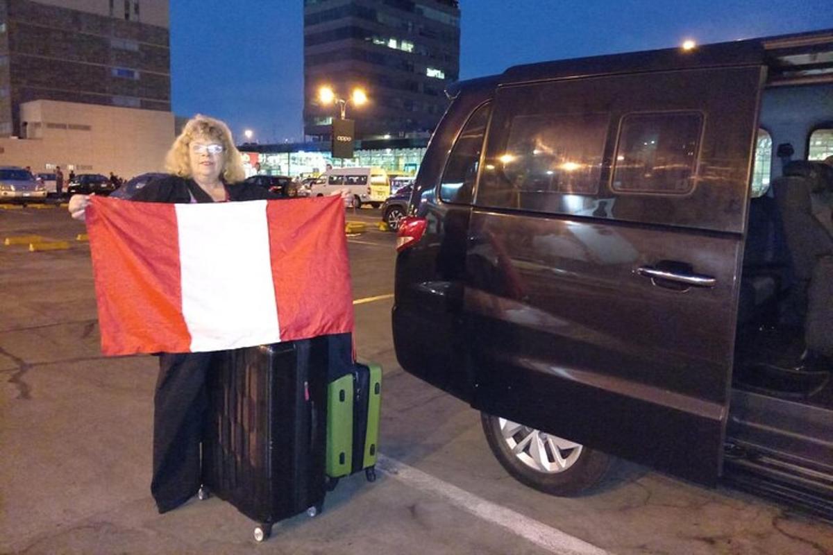 žena držící vlajku vedle černé dodávky