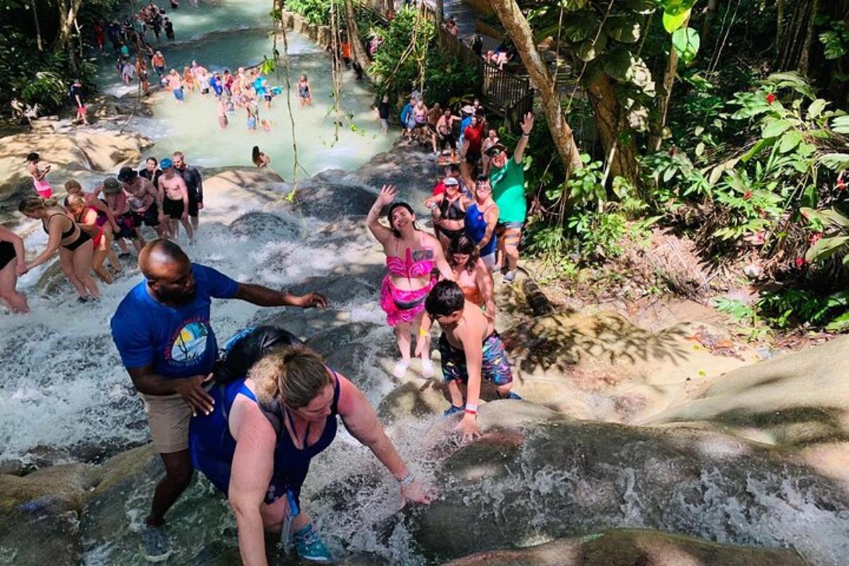 a group of people in the water at a waterfall