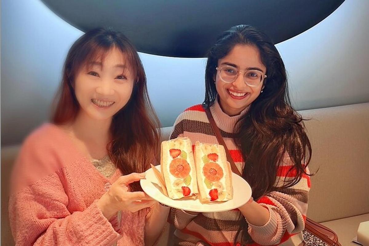 two women holding a plate with food on it