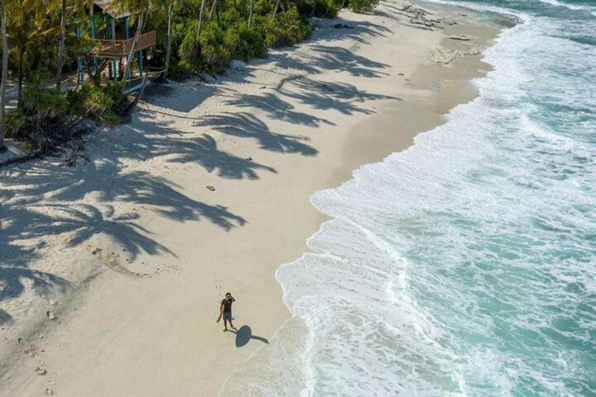 a man walking on a beach next to the ocean