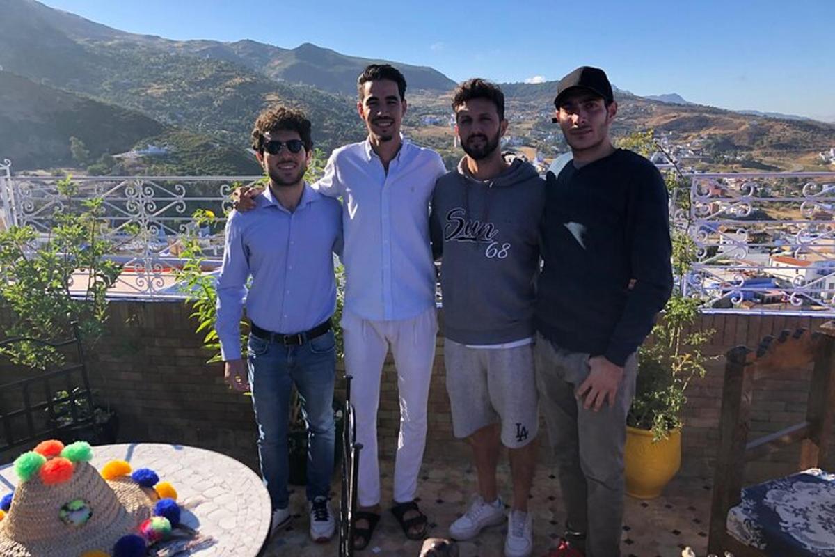 un grup d'homes posant per a una foto en un balcó