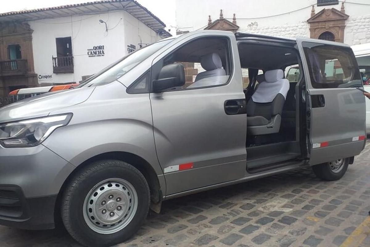 Una camioneta plateada estacionada en un estacionamiento con la puerta abierta