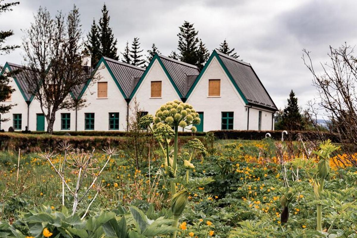uma grande casa branca com um jardim na frente