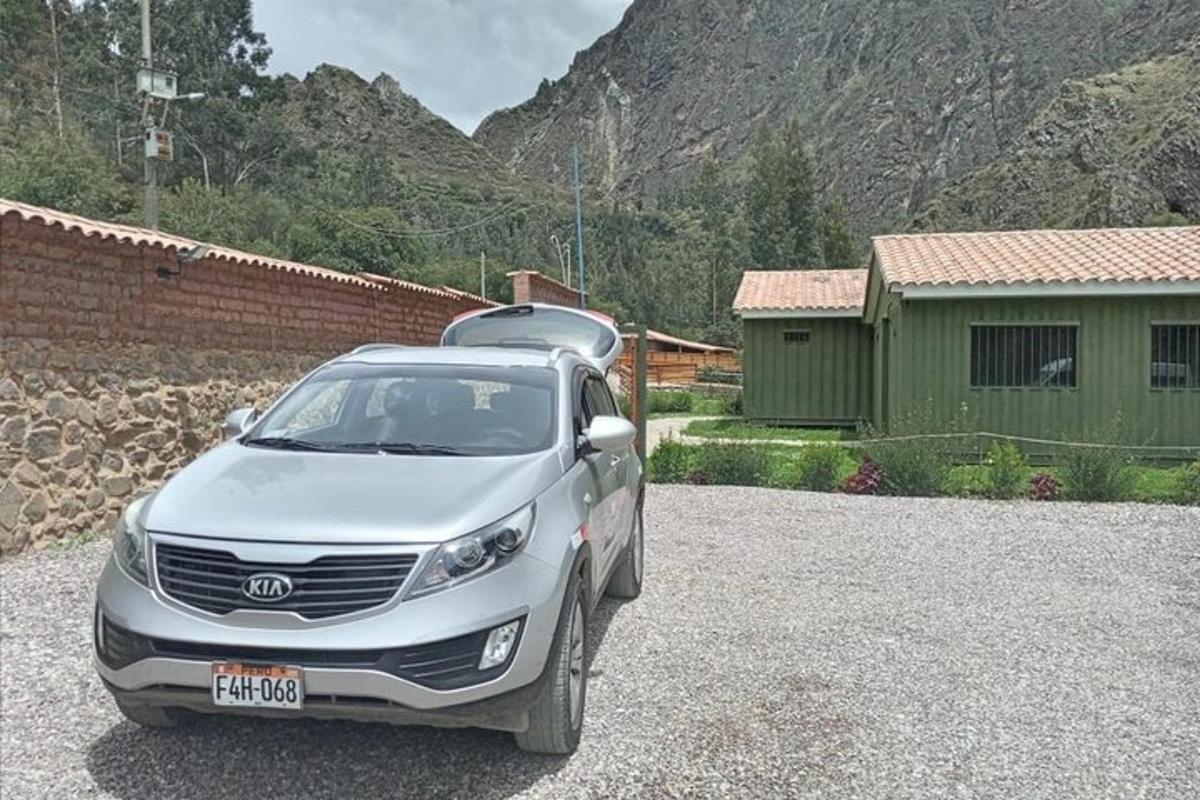 Un coche plateado aparcado en un estacionamiento de grava.