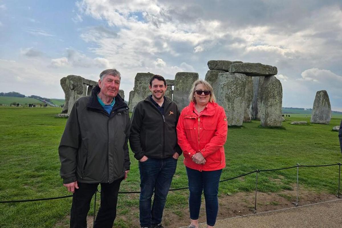 hai người đàn ông và một người phụ nữ đứng trước stonehenge