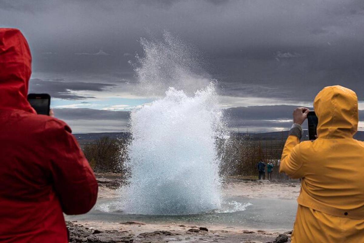 two people taking pictures of a splash of water