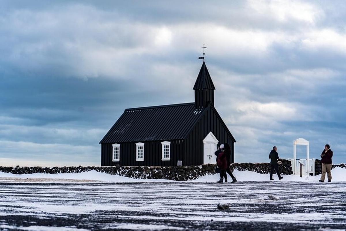 un gruppo di persone in piedi davanti a una chiesa nera